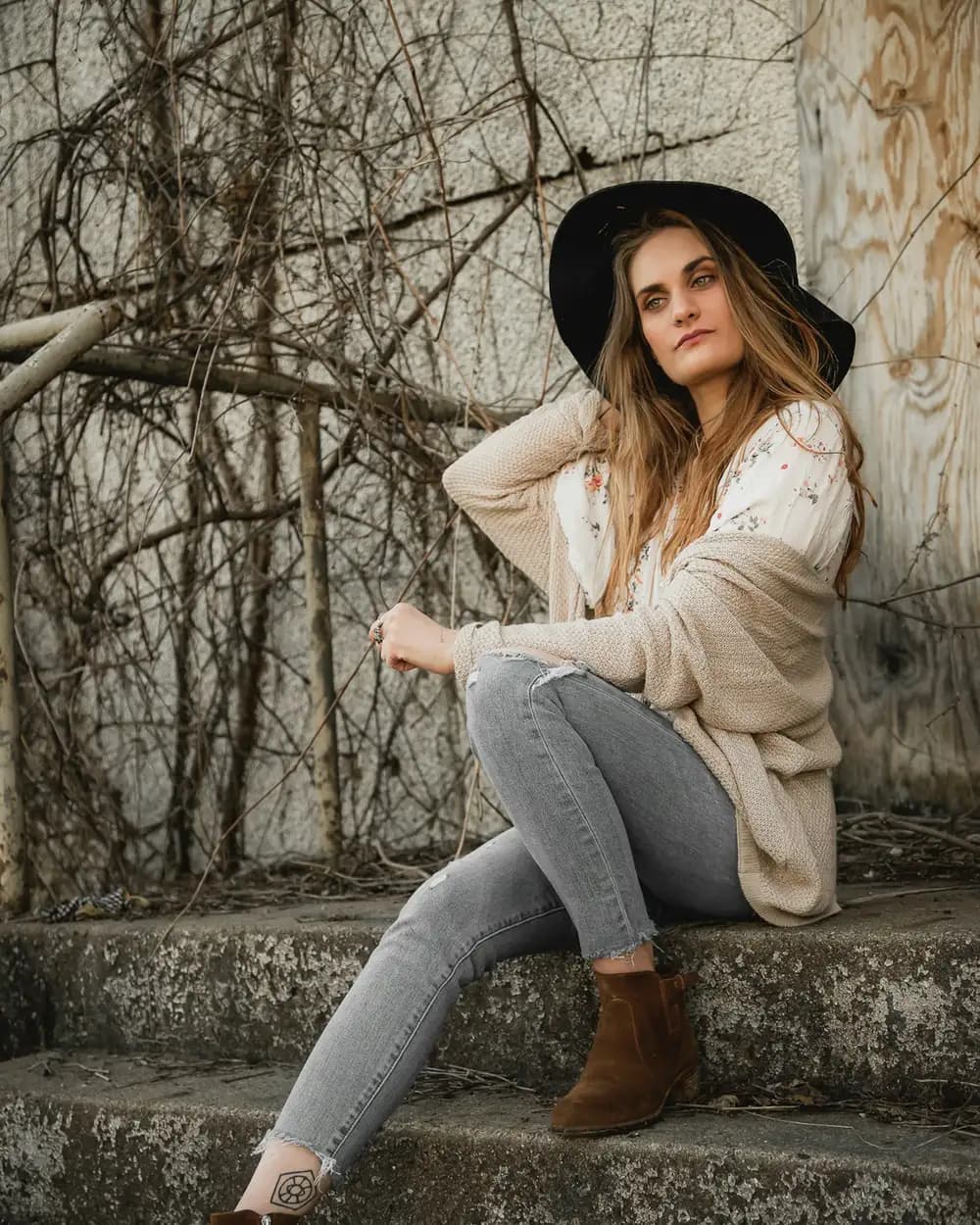 A woman in a cream cardigan sitting on stone steps